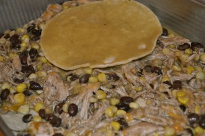 adding layers for chicken enchilada casserole
